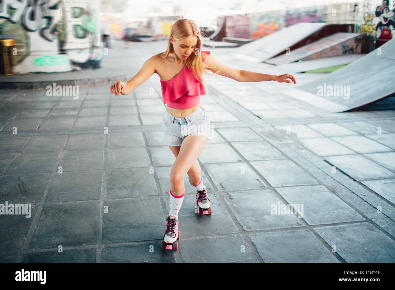 Wellbuilt and slim girl is posing on camera. She is looking down to