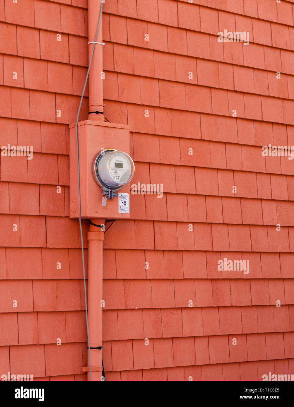 A red round digital electricity meter on cedar shingles in Charlottetown, Prince Edward Island, Canada Stock Photo