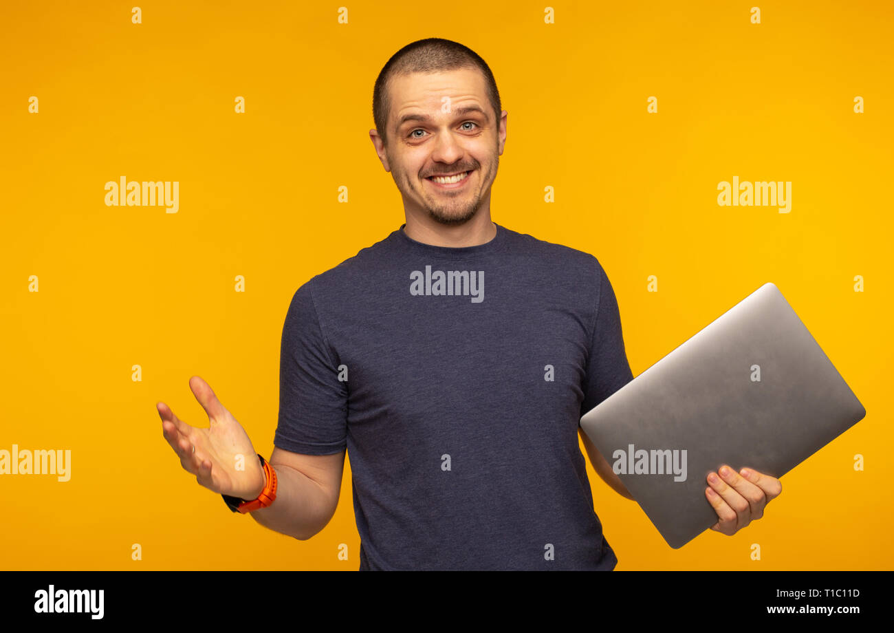 Surprised man freelancer or developer holding laptop and smiling Stock Photo