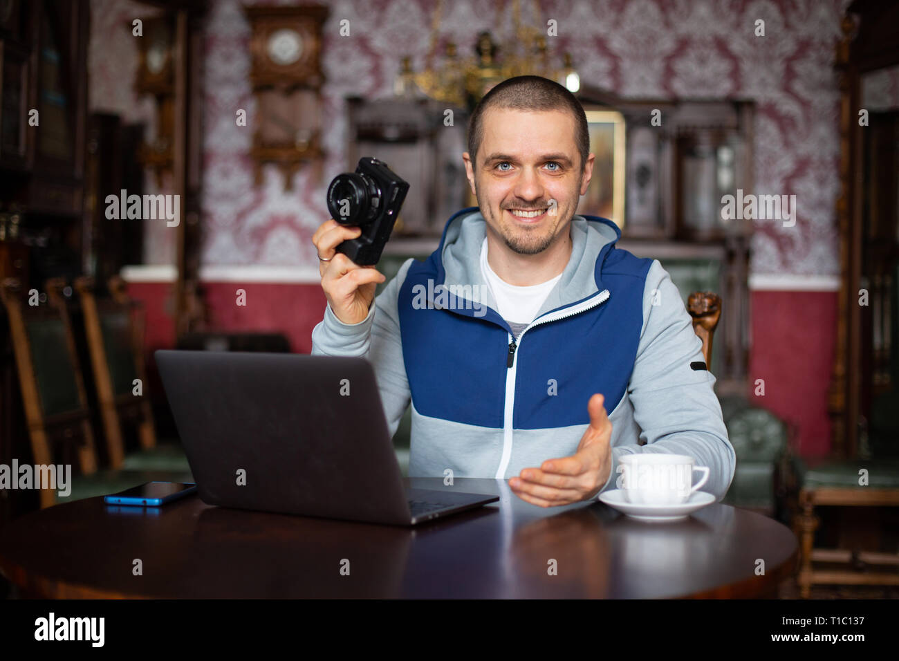 Man blogger holding camera in hand and telling something Stock Photo