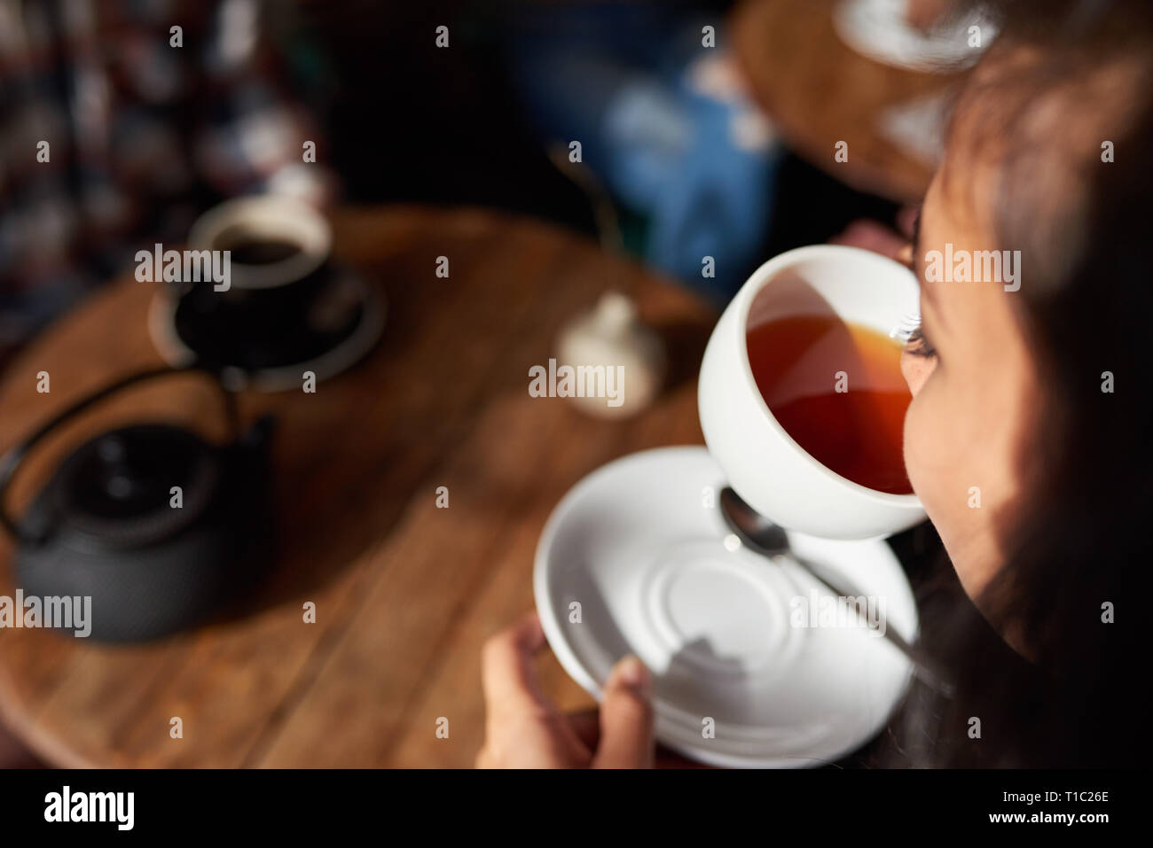 Young woman sitting in a cafe drinking tea Stock Photo