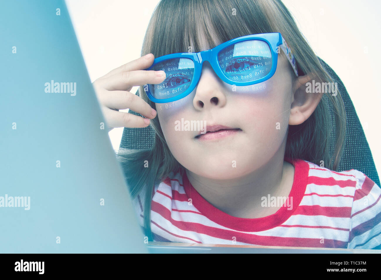Technology genius concept. Little girl programming on a laptop Stock Photo