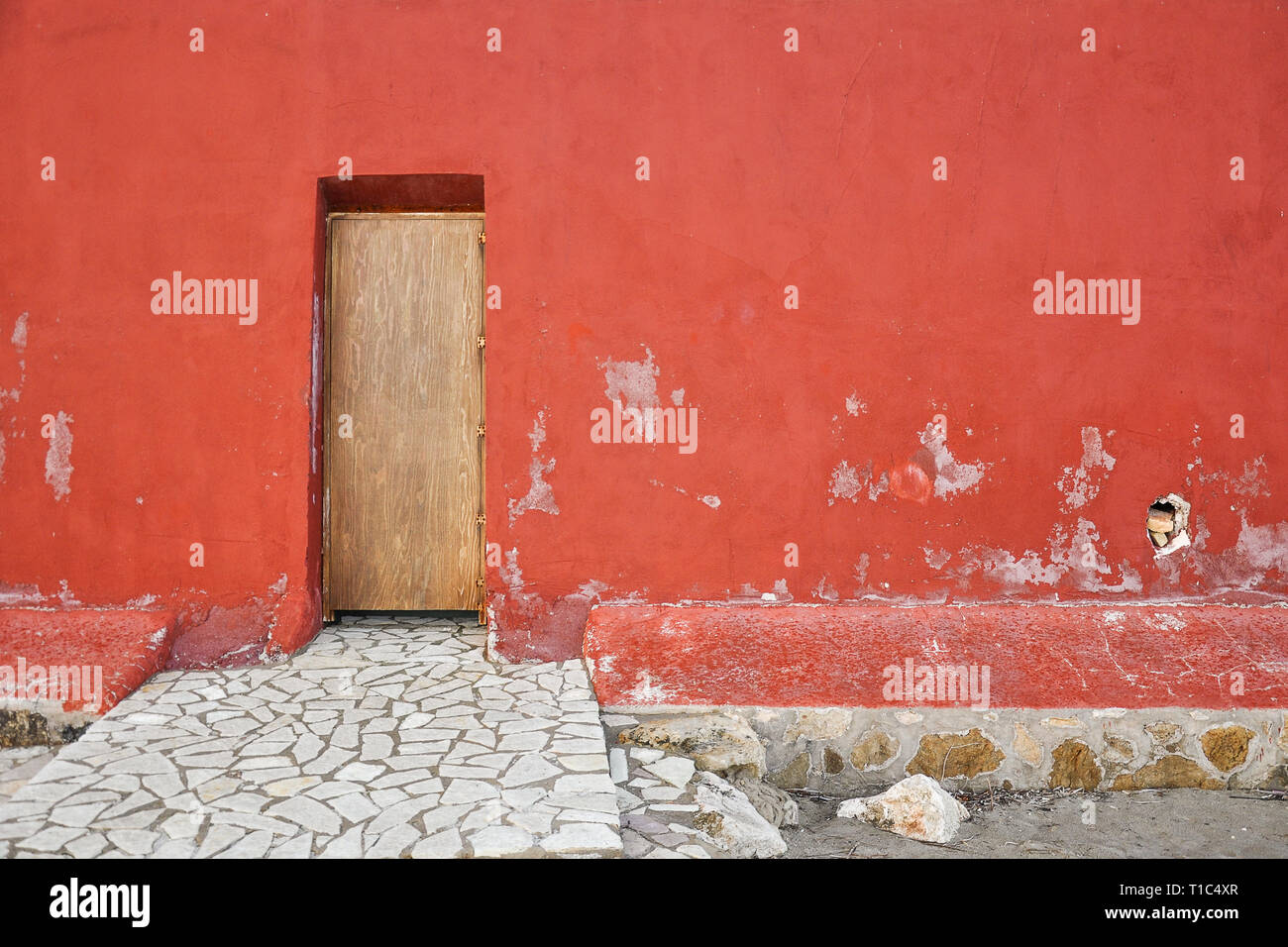 Exterior Red Wall With Wooden Doors And Stone Sidewalk View On