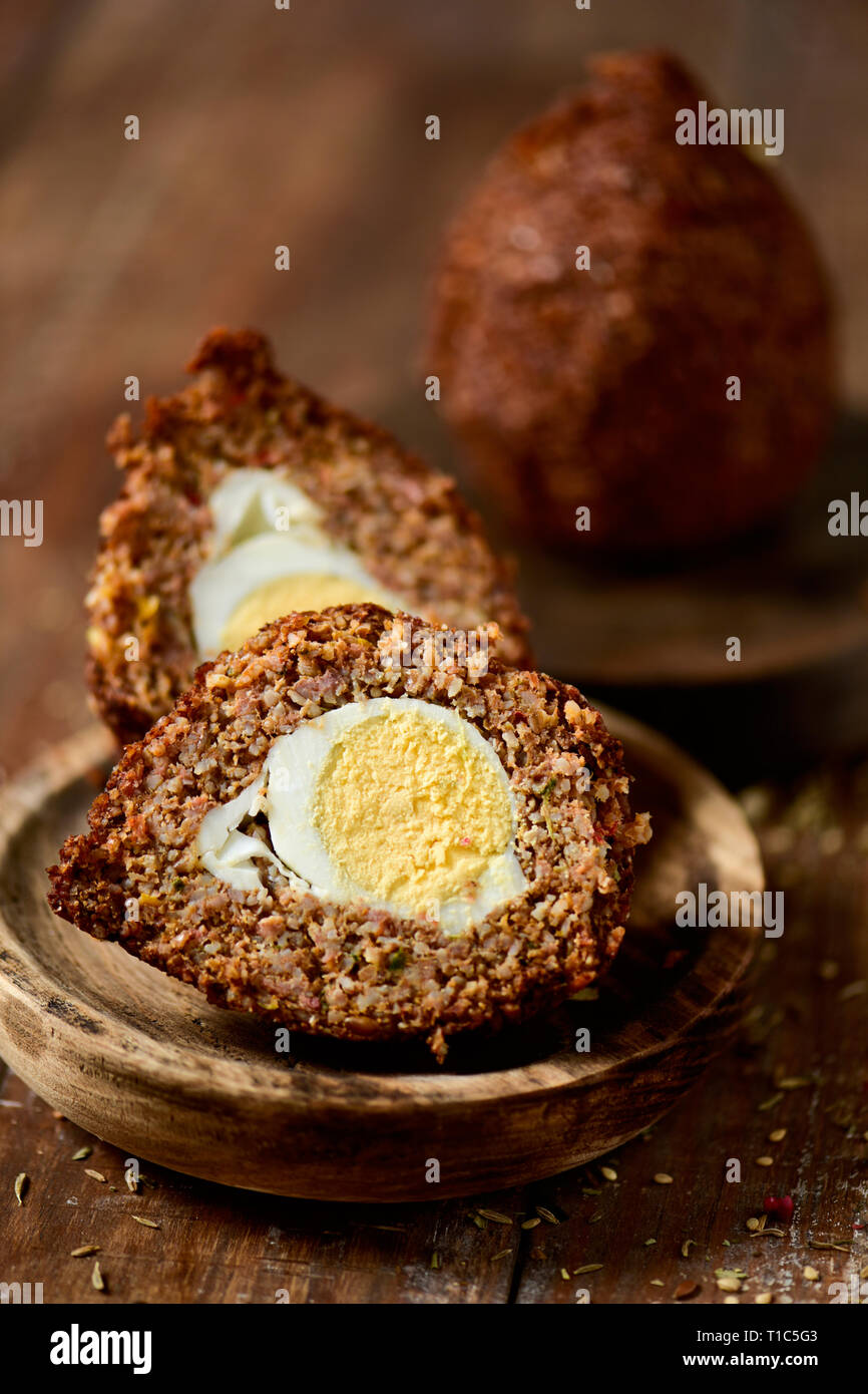 some kibbeh, a levantine dish, made of bulgur, onion, minced meat and different spices, on a rustic wooden table Stock Photo