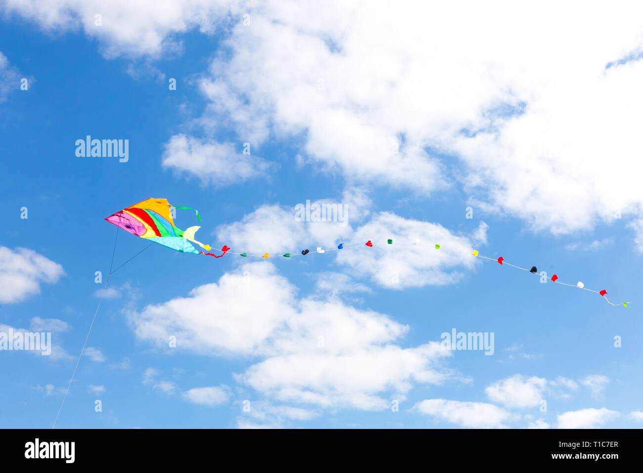 Colorful kite on a blue sky with white clouds Stock Photo Alamy