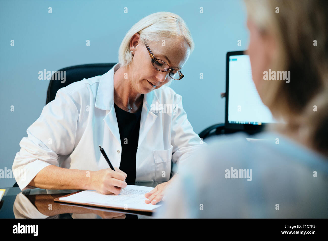 Health Care Worker Talking To Sick Senior Patient In Hospital Stock Photo