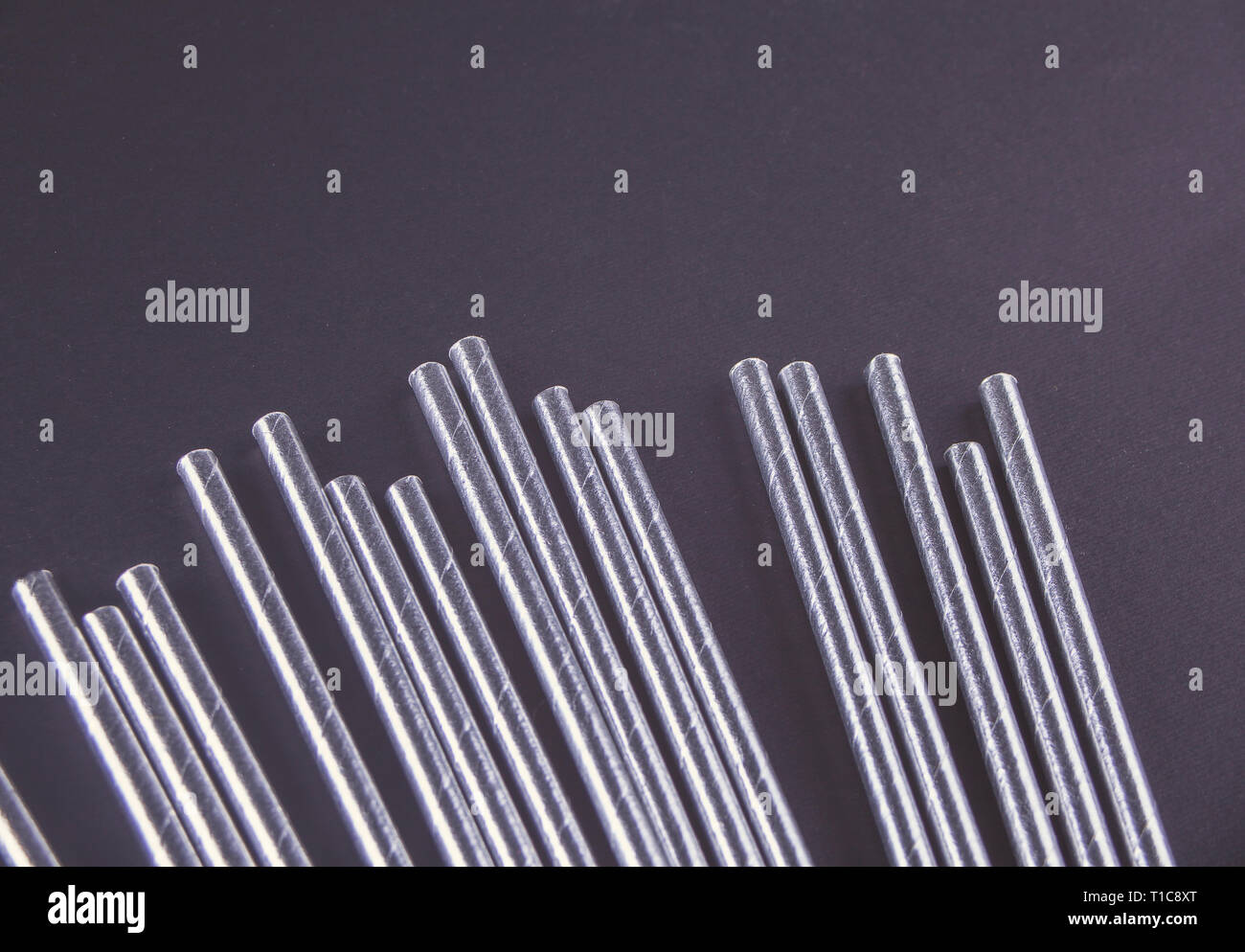 Drinking paper straws for summer cocktails on black background. Top view. Stock Photo