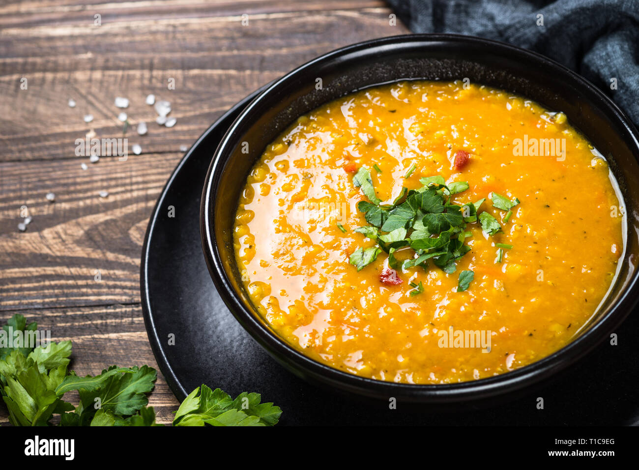 Red lentil soup in black bowl. Stock Photo