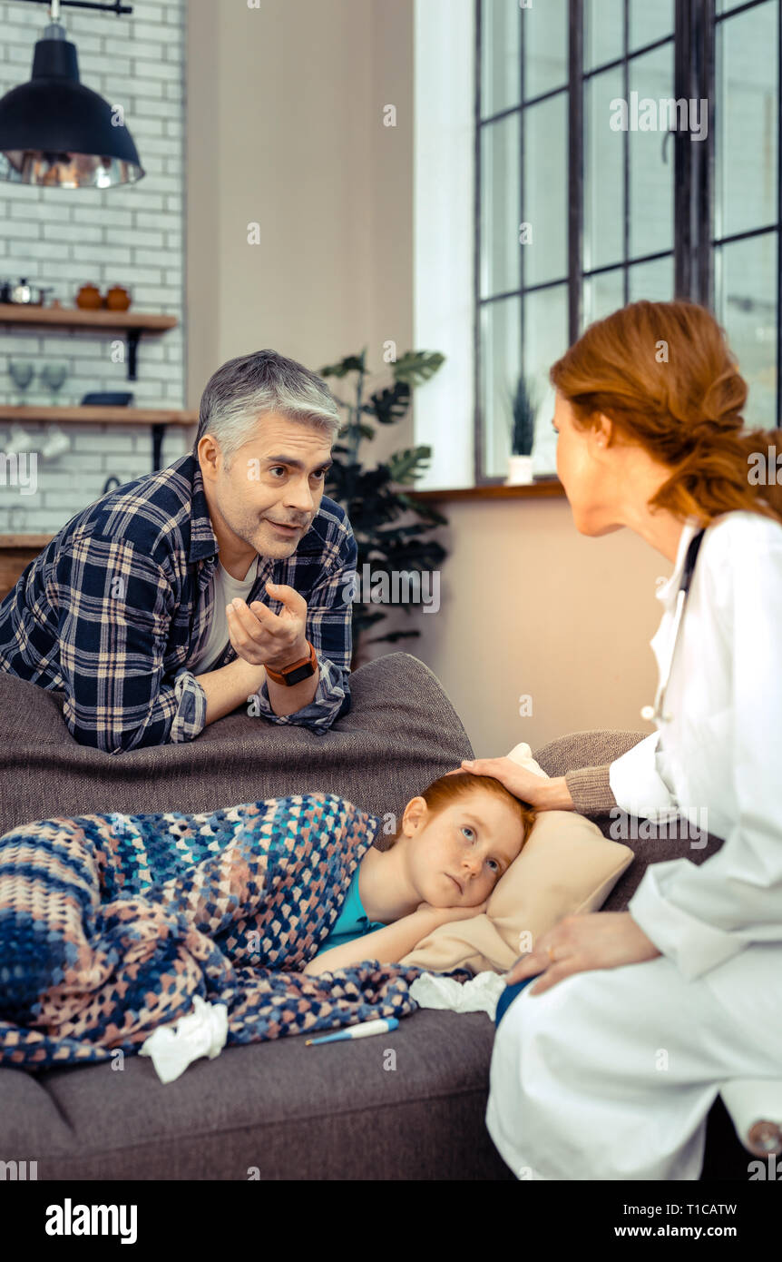 Pleasant nice man looking at the doctor Stock Photo