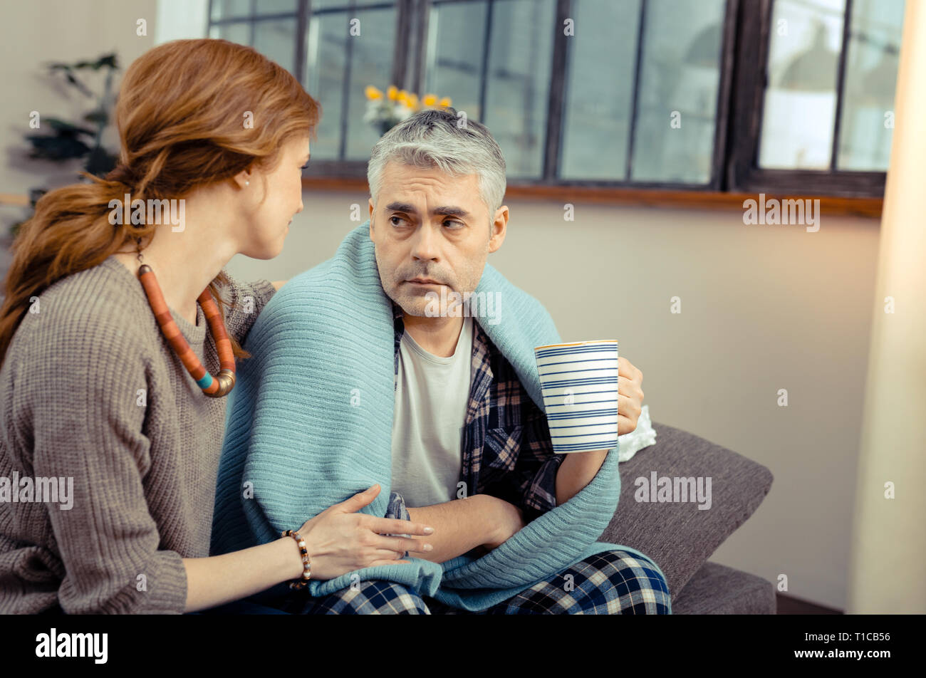 Cheerless sad man sitting with a cup of tea Stock Photo - Alamy