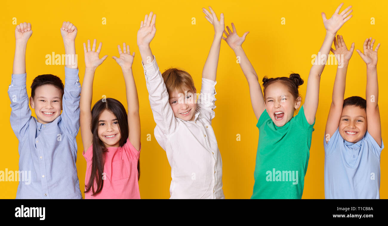 Happy school children raised hands hi-res stock photography and images ...