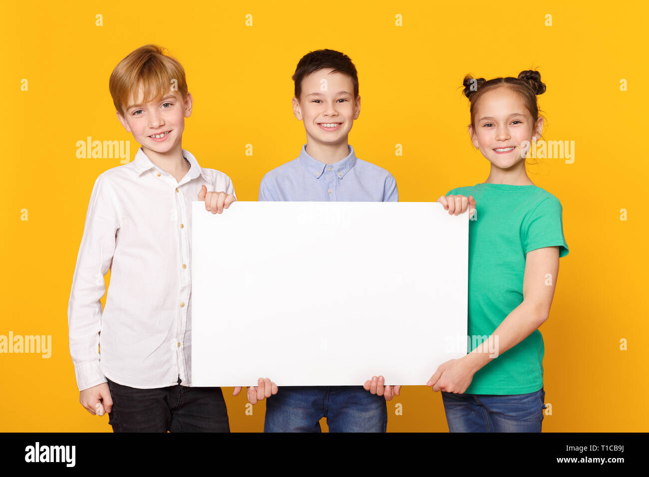 Happy children holding blank banner for advertisement Stock Photo - Alamy