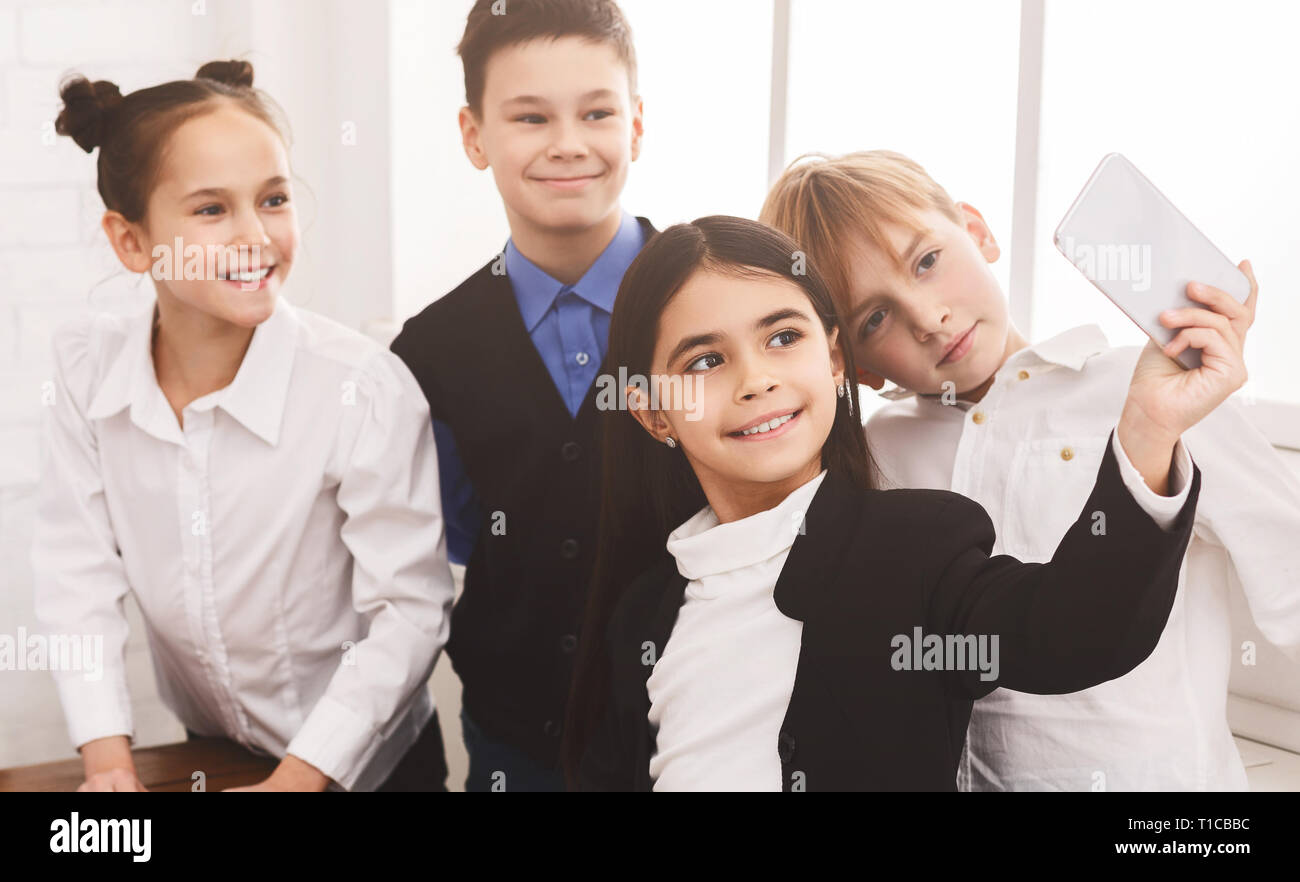 School kids taking selfie on smartphone in corridor Stock Photo