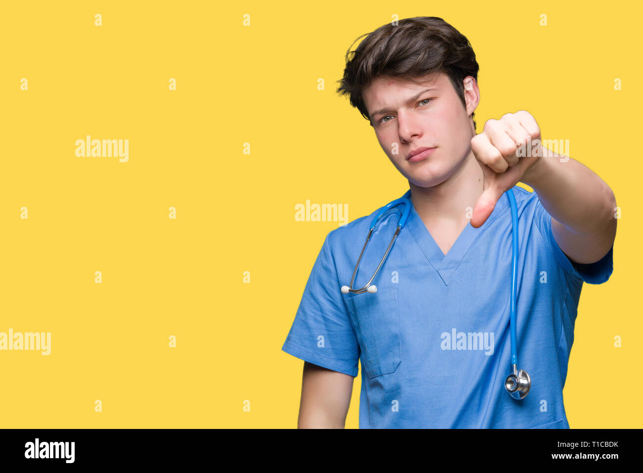 Young doctor wearing medical uniform over isolated background looking ...