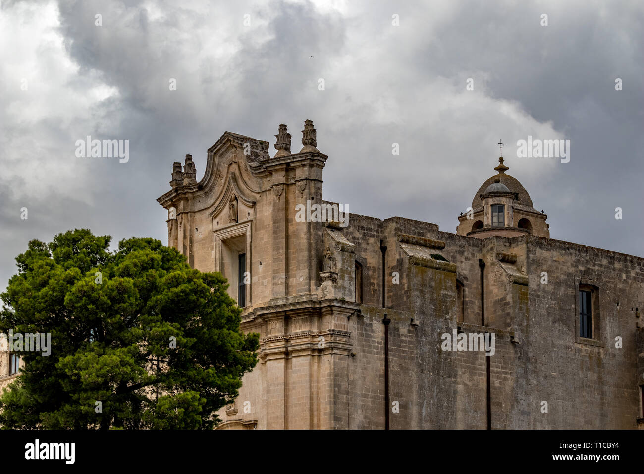 Church tower, roof and entry arch of Chiesa di Sant'Agostino, view of ancient town of Matera, Basilicata, Southern Italy, cloudy summer warm August da Stock Photo