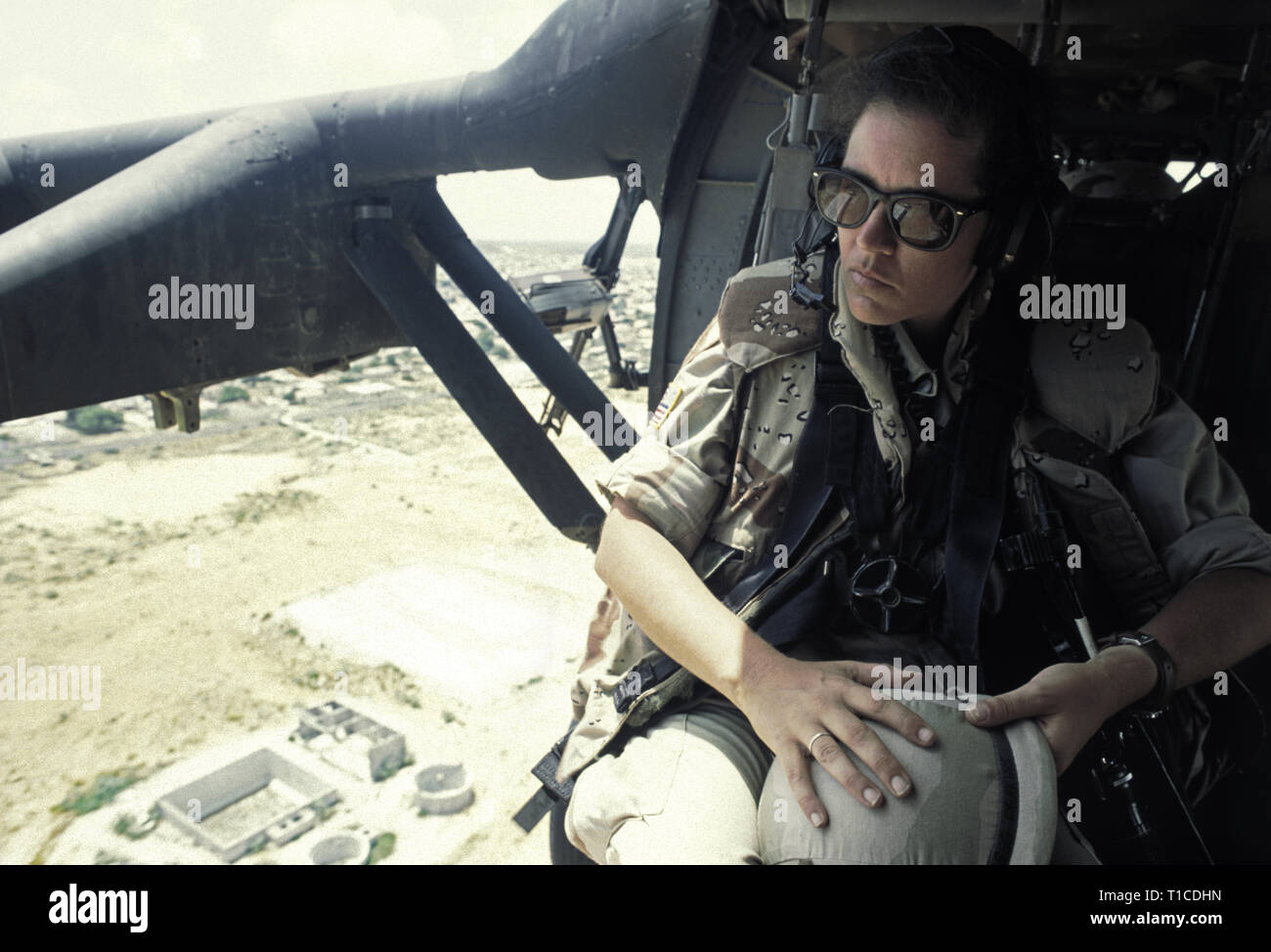 29th October 1993 A female U.S. Army soldier sits at the open doorway of a US Army Sikorsky UH-60 Black Hawk helicopter as it flies over Mogadishu, Somalia. Stock Photo