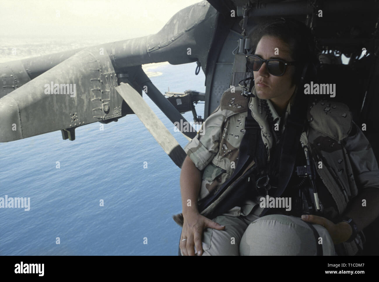 29th October 1993 A female U.S. Army soldier sits at the open doorway of a US Army Sikorsky UH-60 Black Hawk helicopter as it flies over the Indian Ocean just off Mogadishu, Somalia. Stock Photo
