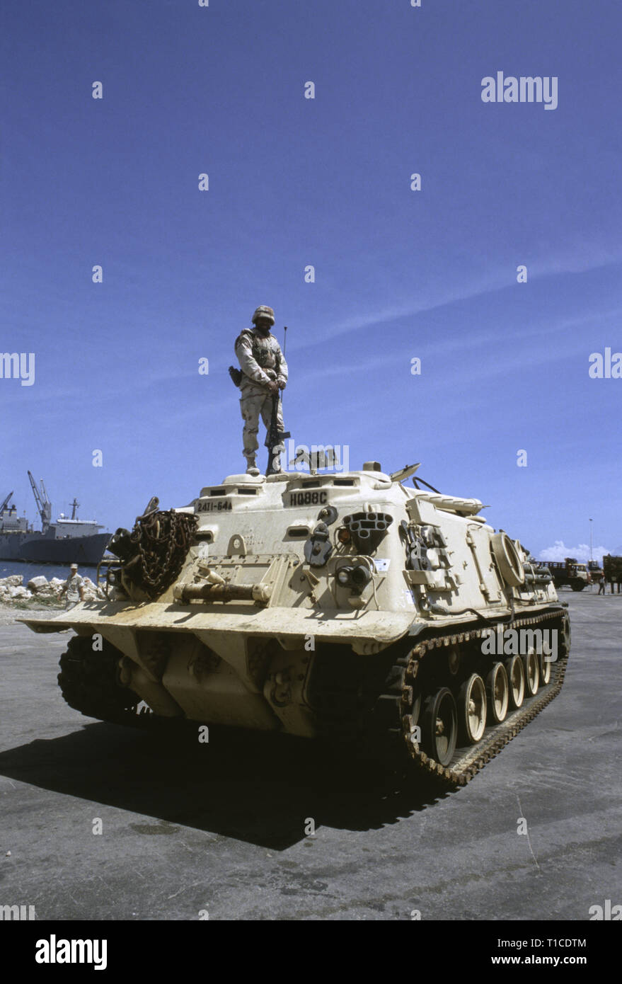 29th October 1993 A U.S. Army soldier of the 24th Infantry Division, 1st Battalion of the 64th Armored Regiment, stands on top of his M88 recovery vehicle, in the port in Mogadishu, Somalia where it has just arrived by sea. Stock Photo