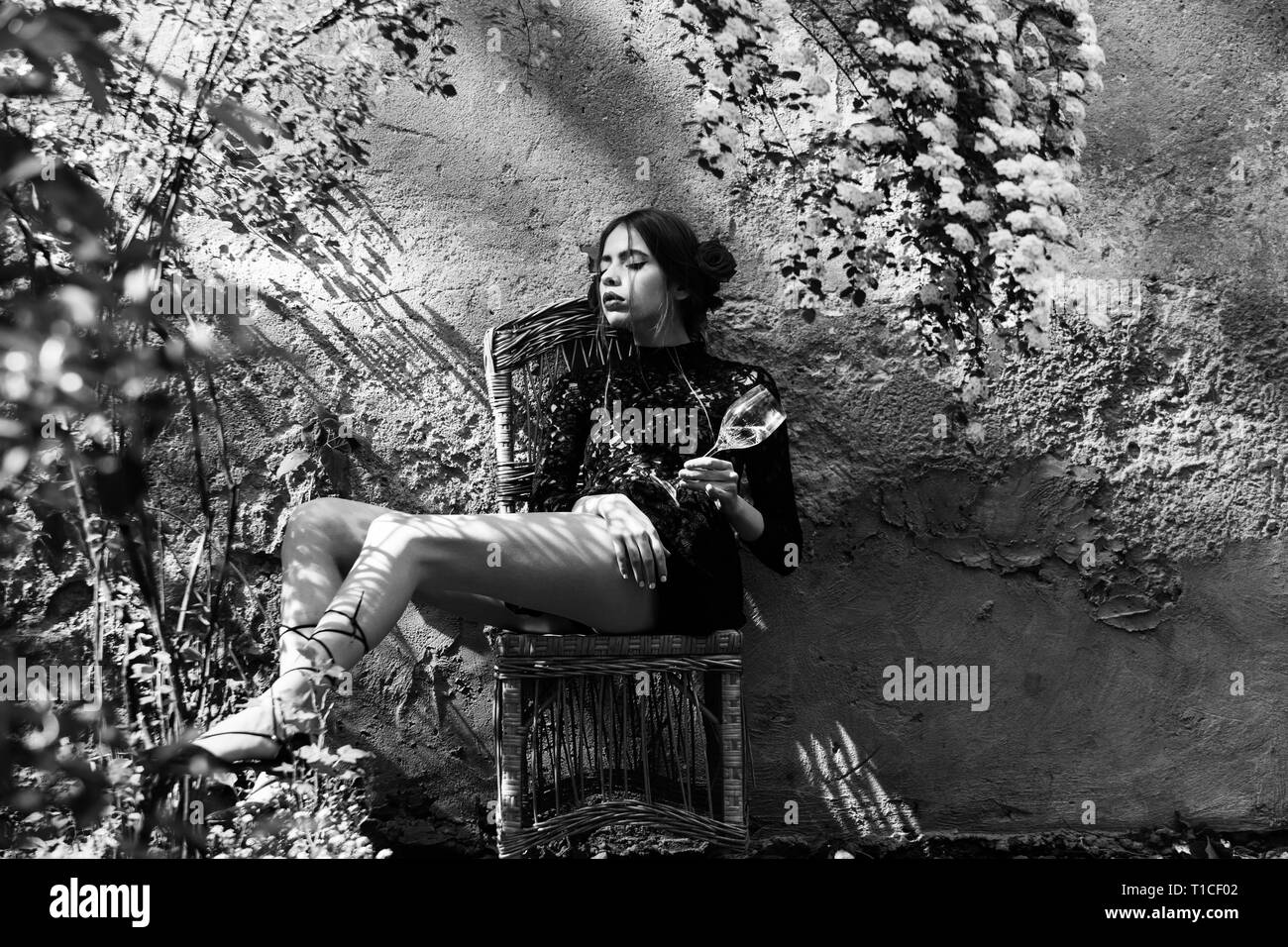 Pretty girl with closed eyes and glass sitting on chair Stock Photo - Alamy