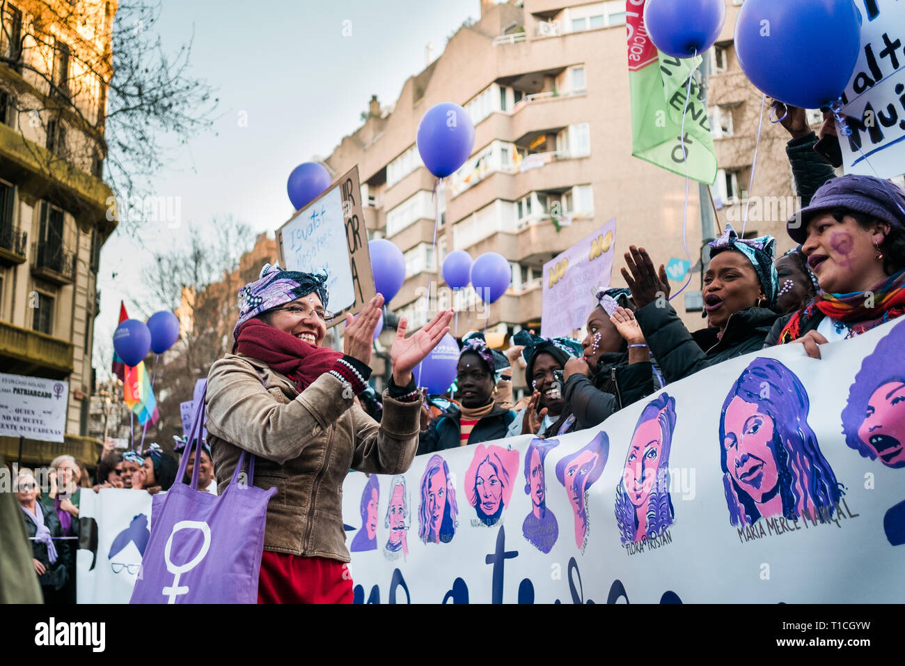 Barcelona, Spain - 8 march 2019:  women chanting and calpping in the city during woman's day with purple balloons Stock Photo