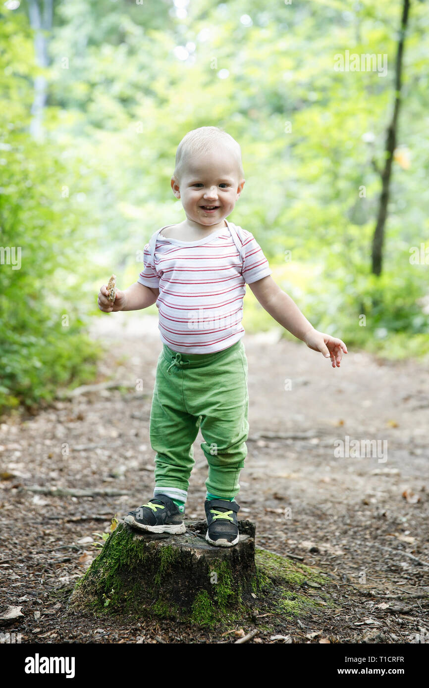 Boy standing on a stump, proud of his achievement of learning to walk ...