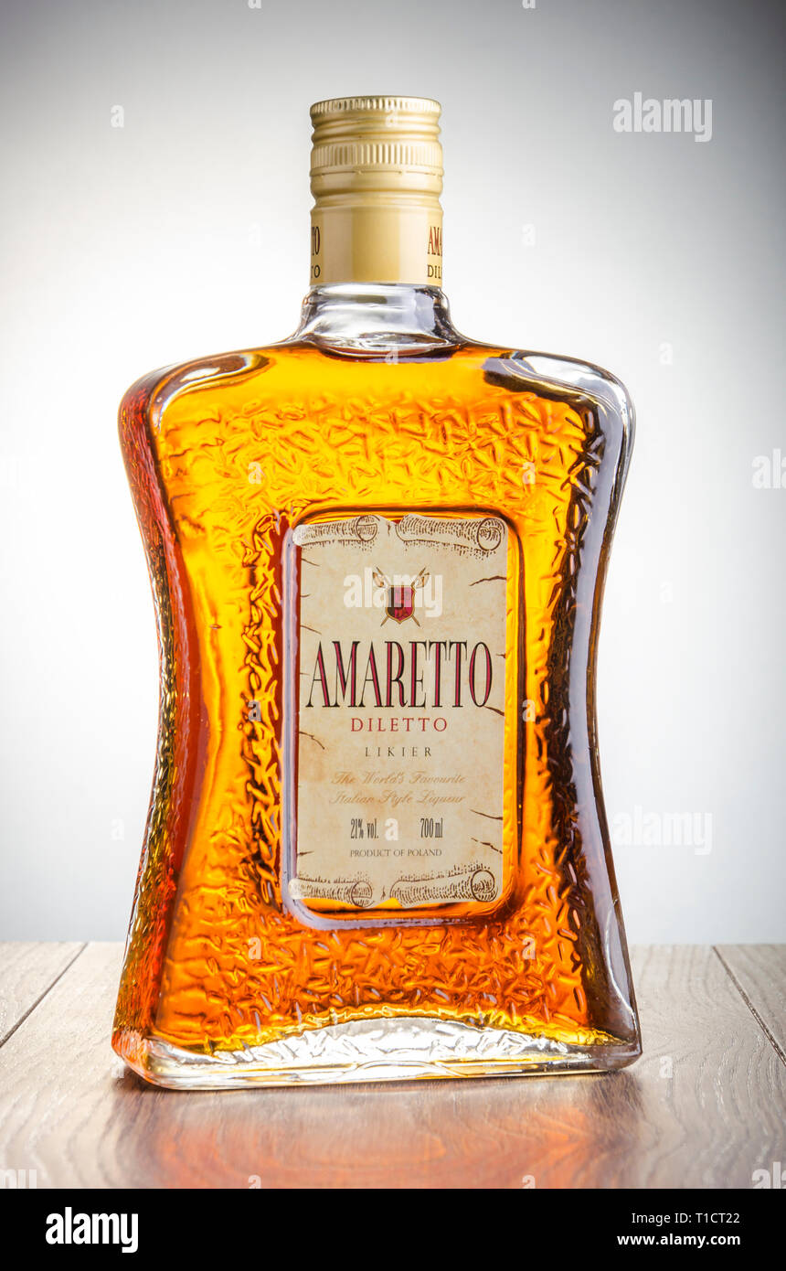Bottle of Amaretto liqueur on gradient background. Amaretto comes from
