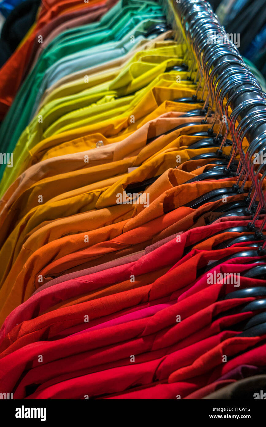 Male menâ€™s shirts sorted in color order on hangers on a shop wardrobe ...