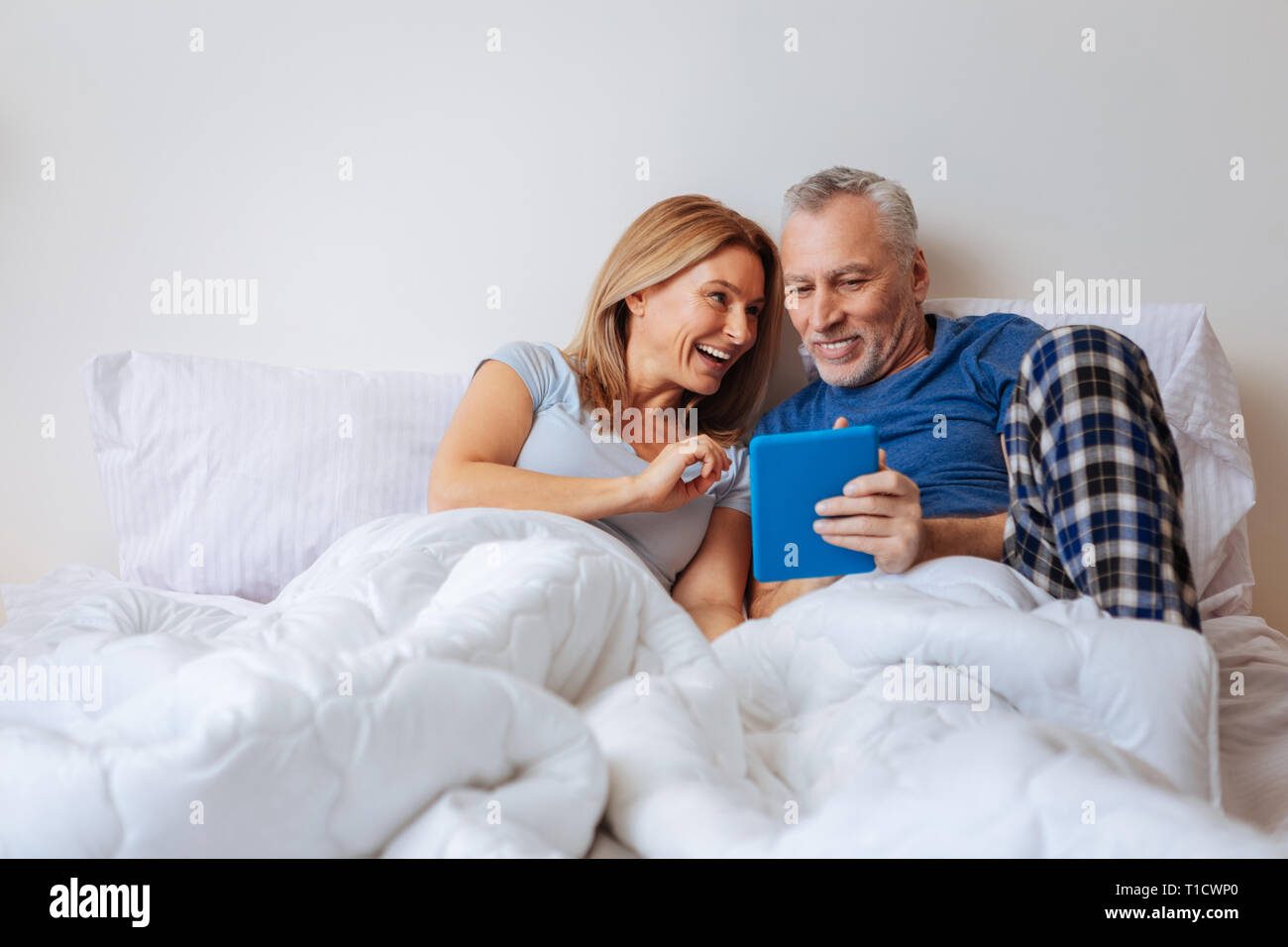 Wife feeling entertained while watching comedy with husband Stock Photo