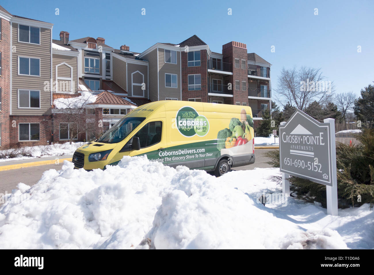 Coborns truck delivers groceries in spring snow to an apartment complex. St Paul Minnesota MN USA Stock Photo
