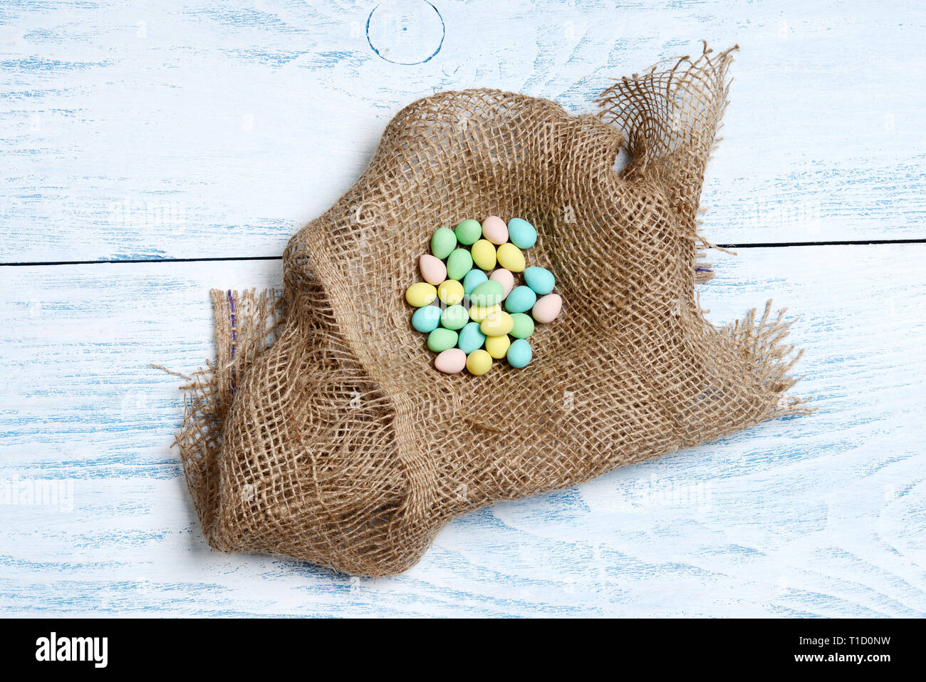 Burlap nest with colorful easter eggs Stock Photo