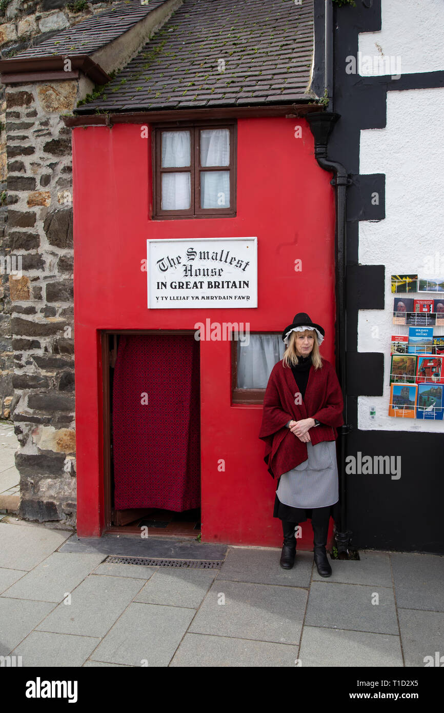 Lady dressed in traditional Welsh costume standing outside the smallest house in Great Britain at Conwy in North Wales Stock Photo