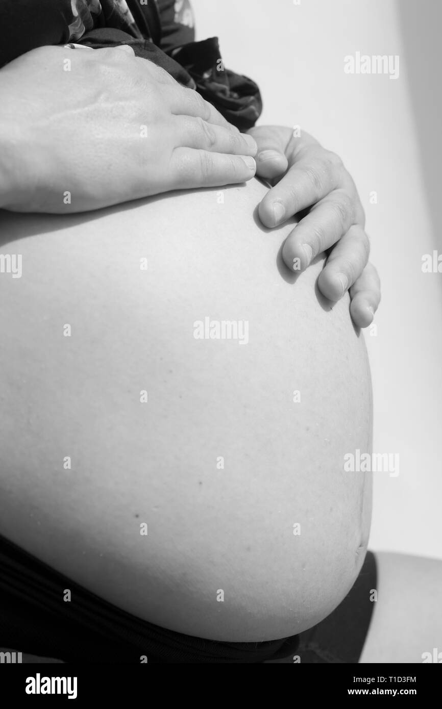 Close-Up of Pregnant Woman with her Hands on Belly Stock Photo