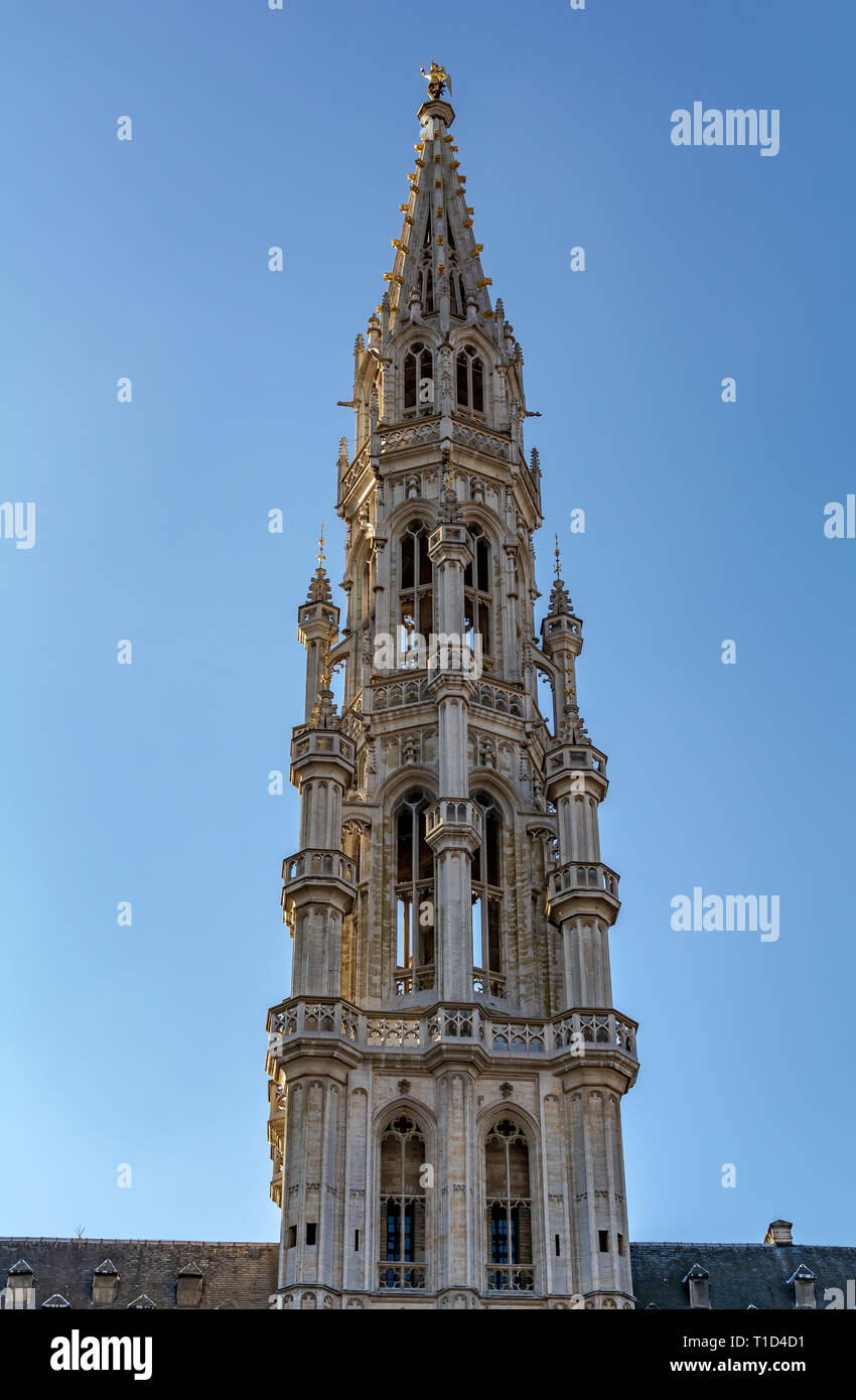 The tower of The Brussels Town Hall in Brabantine Gothic style with lavishly pinnacled octagonal openwork. Atop the spire stands gilt metal statue of  Stock Photo