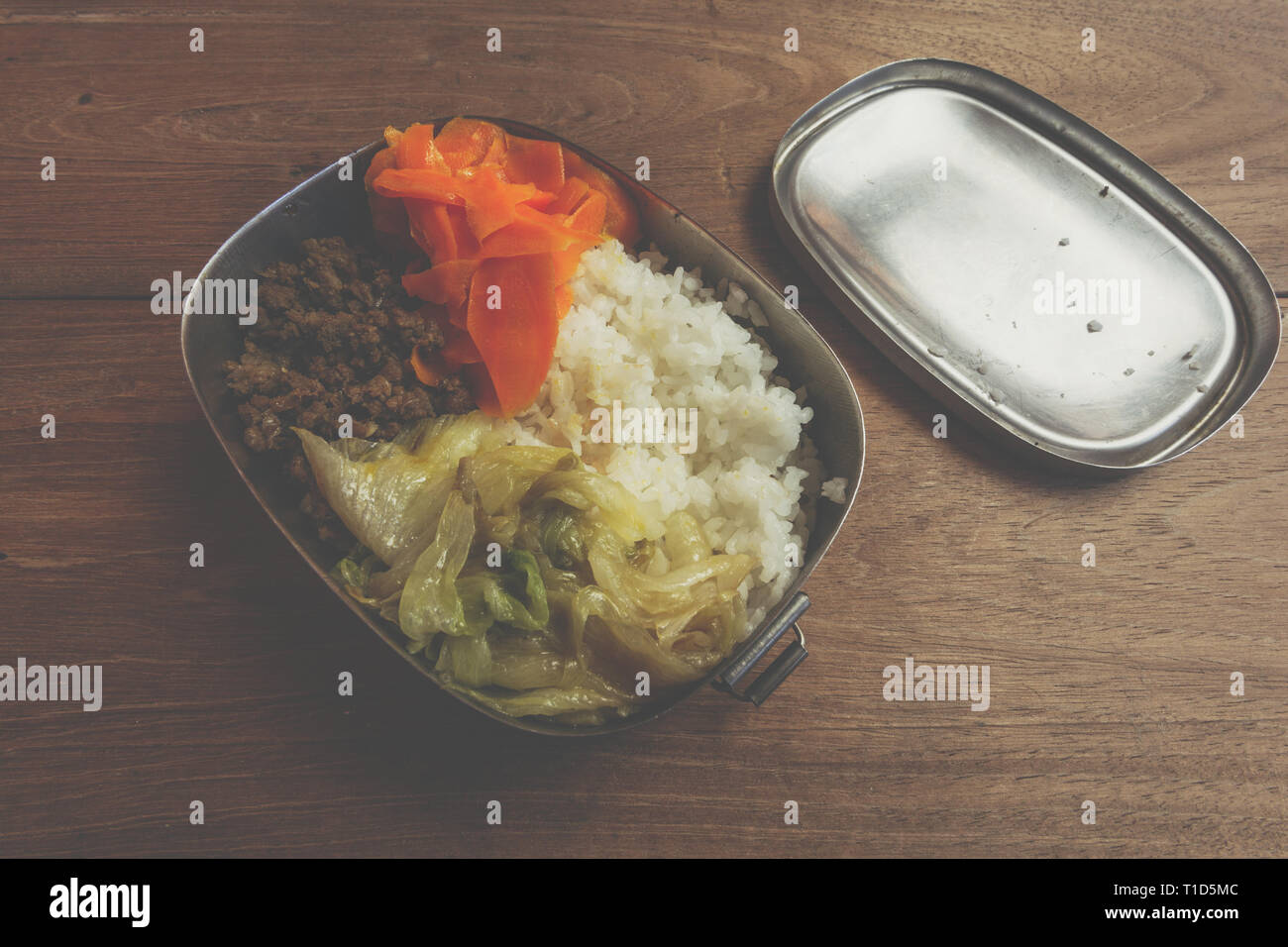 Ground beef, carrot, cabbage lettuce (iceberg lettuce), rice, food ready to eat, in stainless steel bento lunch box Stock Photo