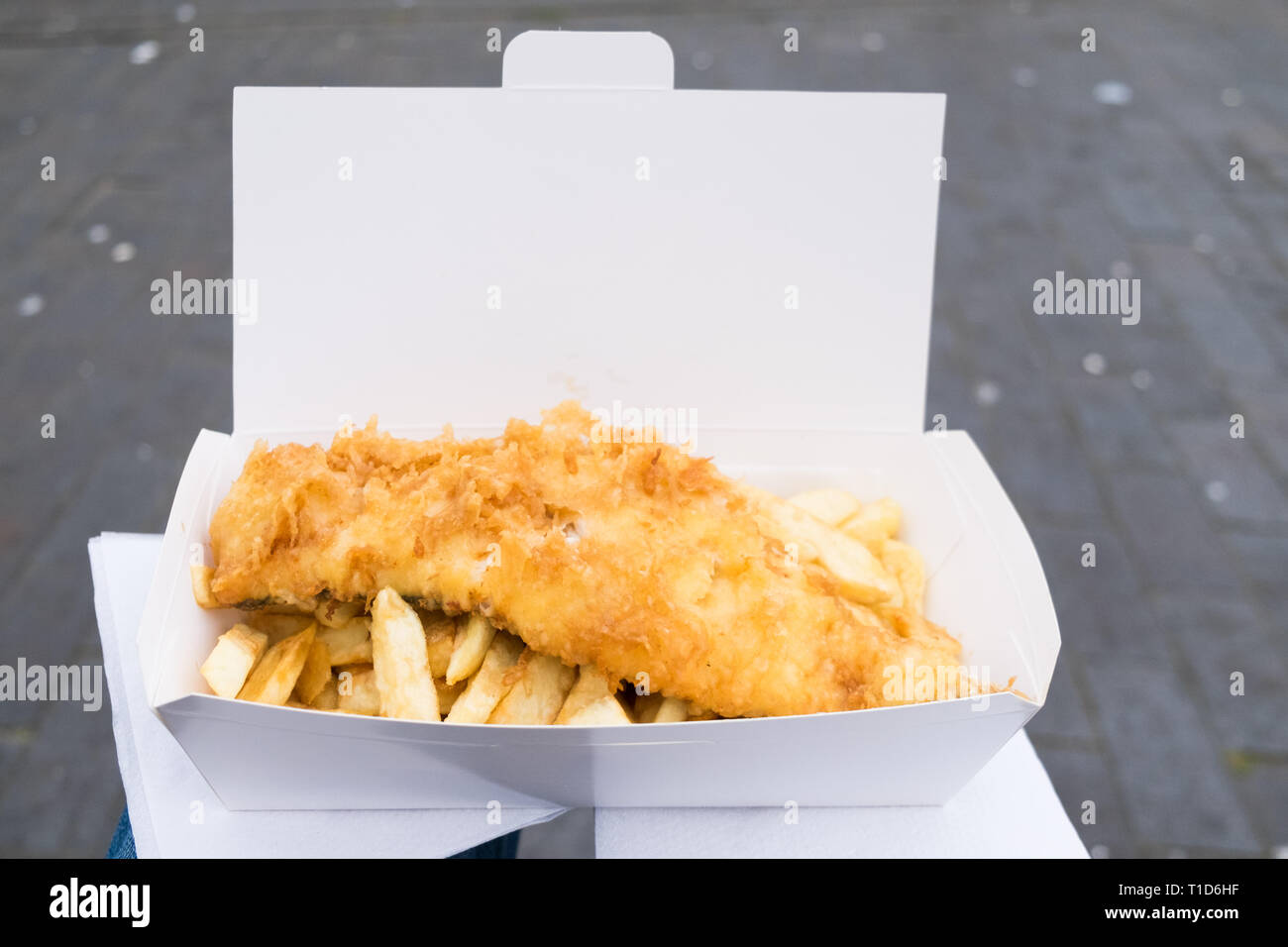 Fish and chips balanced on my lap from No1 Fish & Chips Shop in Cromer, North Norfolk, England. Stock Photo