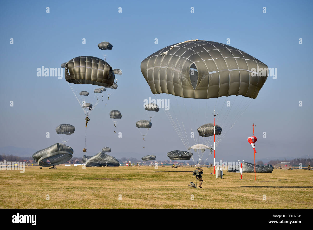 U.S. Army Paratroopers assigned to 1st Battalion, 503rd Infantry Regiment, 173rd Airborne Brigade, descend onto Cerklje Drop Zone in Slovenia, Mar. 22, 2019 after exiting from C17 Globemaster III Aircraft from Papa Air Base, Hungary, during an airborne operation as part of exercise Eagle Sokol. Exercise Eagle Sokol is a bilateral training exercise with the Slovenian Armed Forces focused on the rapid deployment and assembly of forces and team cohesion with weapon systems tactics and procedures. Exercises such as this build a foundation of teamwork and readiness between allied NATO countries. Th Stock Photo