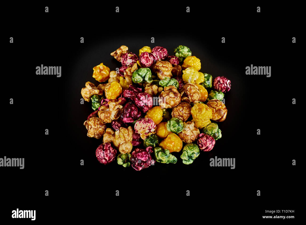multicolored caramel popcorn on a black background. Stock Photo