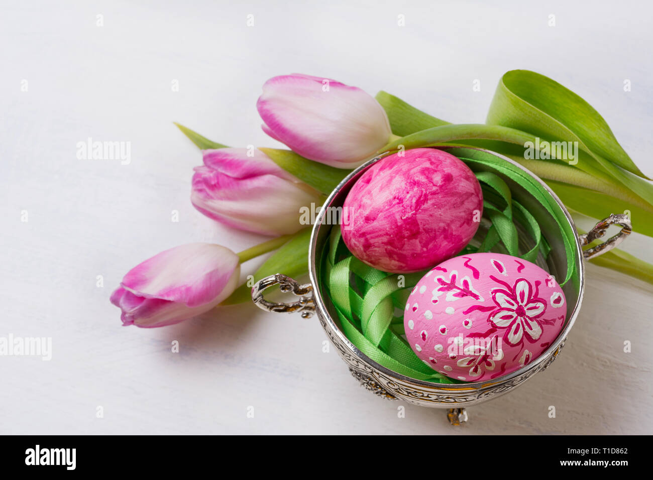 Happy Easter background with pink floral painted eggs in the metal bowl ...