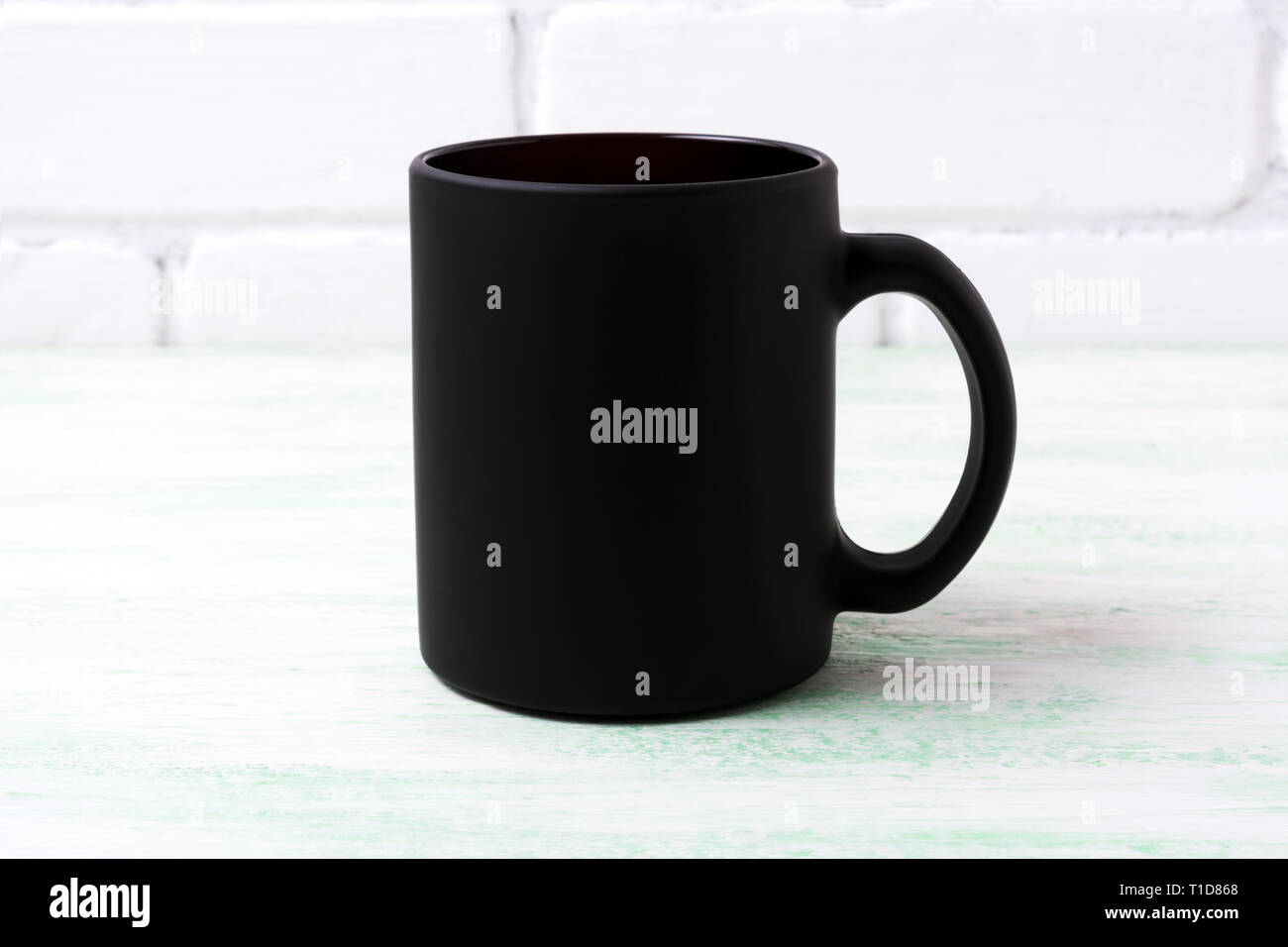 https://c8.alamy.com/comp/T1D868/black-coffee-mug-mockup-with-white-painted-brick-wall-empty-mug-mock-up-for-brand-promotion-T1D868.jpg