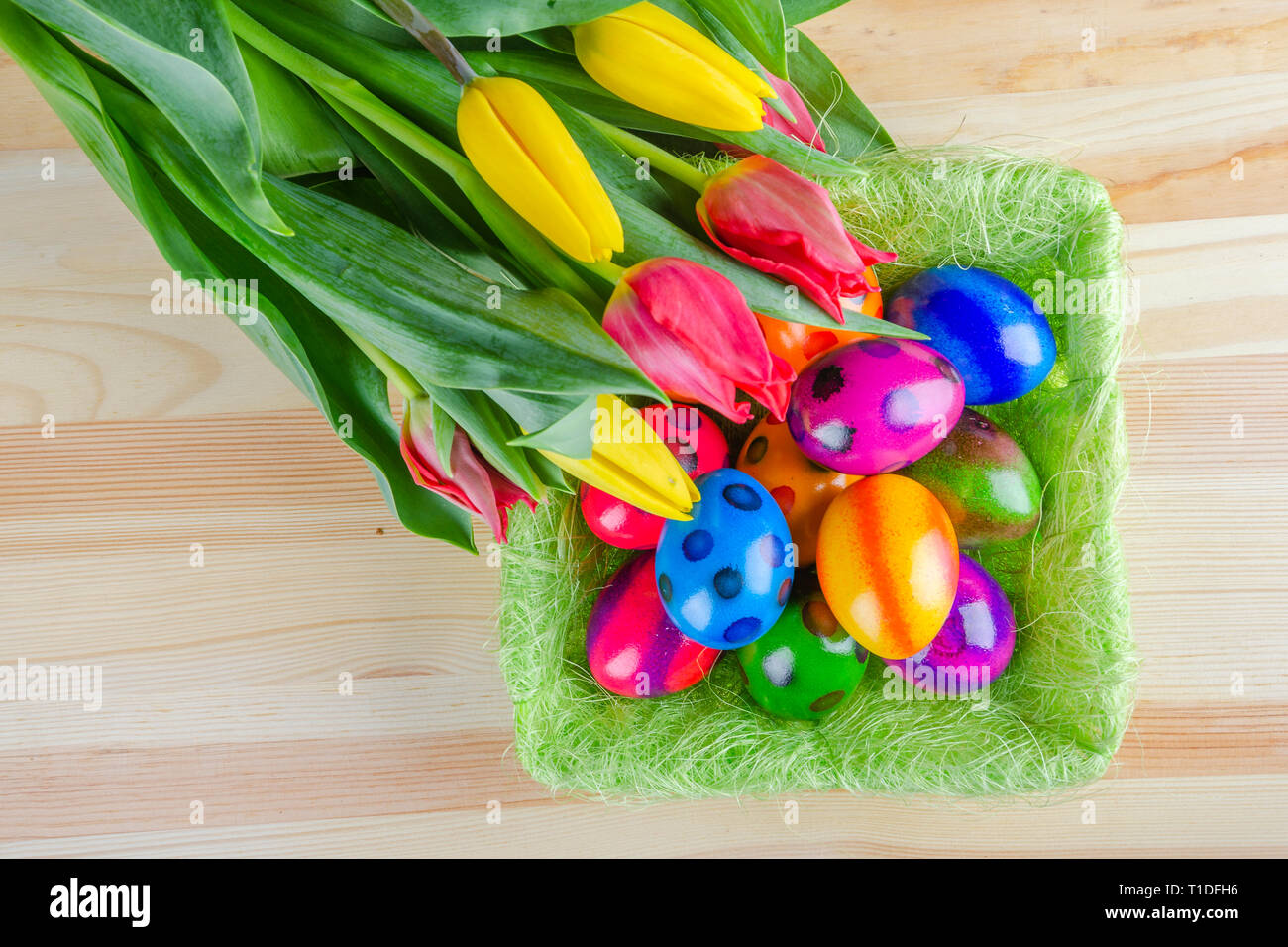 colorful easter eggs and tulip flowers on wooden table Stock Photo - Alamy