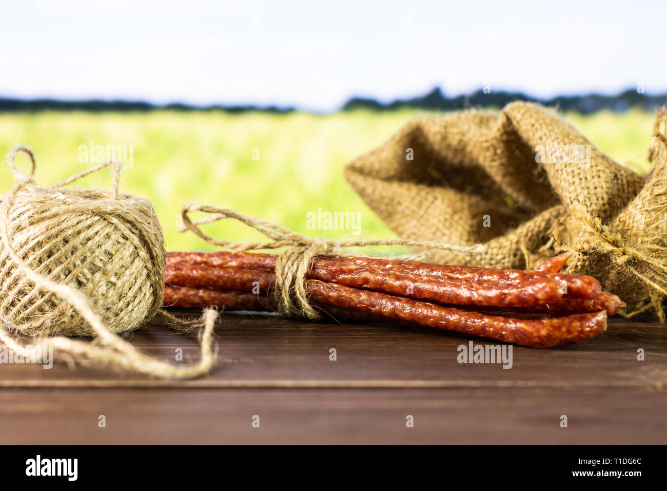 Lot of whole spicy salami stick tyrolini tied by jute in a jute bag ...