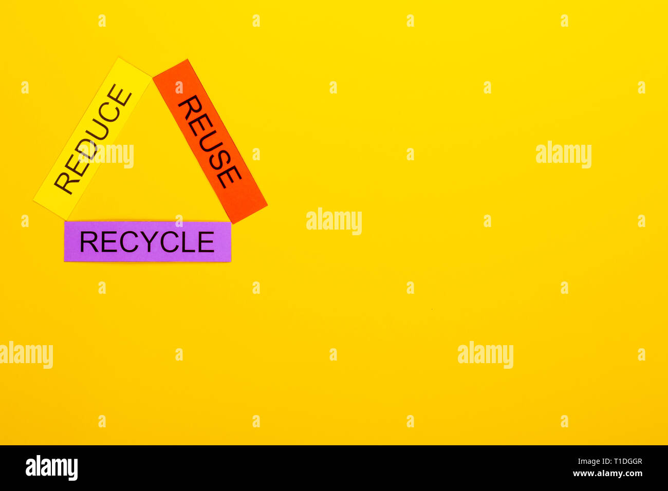 Recycling concept showing reduce, reuse & recycle on a yellow ...