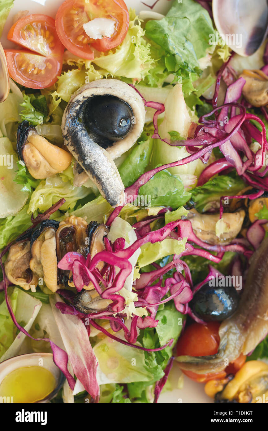 Typical Spanish salad with seafood and anchovies on the restaurant