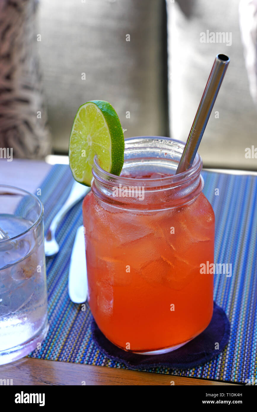 Drinking a pink strawberry lemonade in a mason jar with a straw Stock Photo