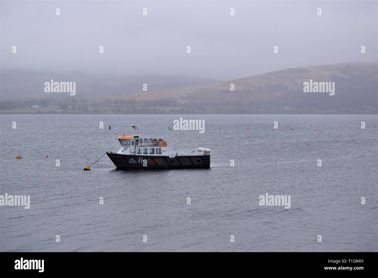 Staffa Tours Boat at anchor in Loch Creran mist. A sense of remote misty isolation in a Scottish sea loch close to the salmon hatchery at Barcaldine. Stock Photo