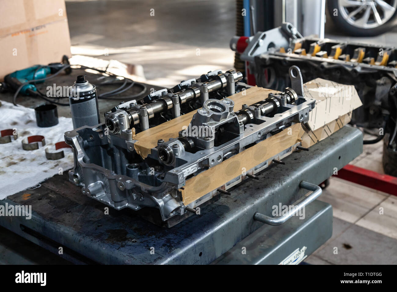 A four-cylinder engine with new camshaft dissembled and removed from car on a workbench in a vehicle repair workshop. Auto service industry. Stock Photo