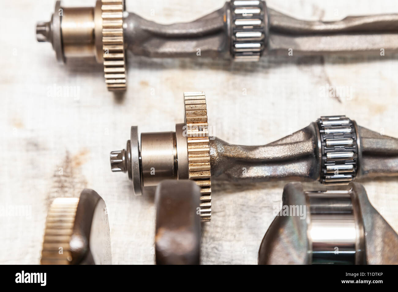 Closeup on a car shaft with gears and bearings removed for replacement on a workbench in a