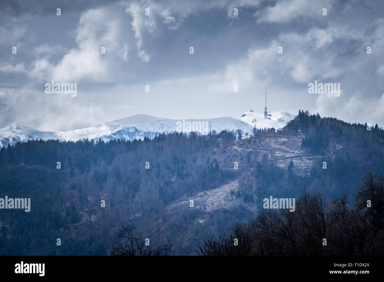 View from lake Ossiacher See to Mountain Dobratsch with radio antenna on  the snowy summit in spring in carinthia Stock Photo - Alamy