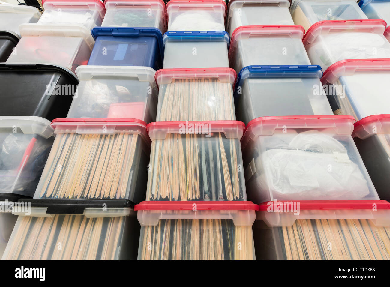 Wall of plastic file storage boxes with folders, binders and miscellaneous supplies. Stock Photo