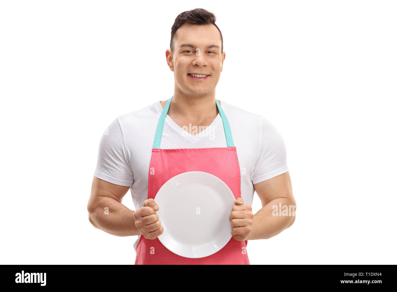 Young guy in an apron showing a clean plate isolated on white background Stock Photo